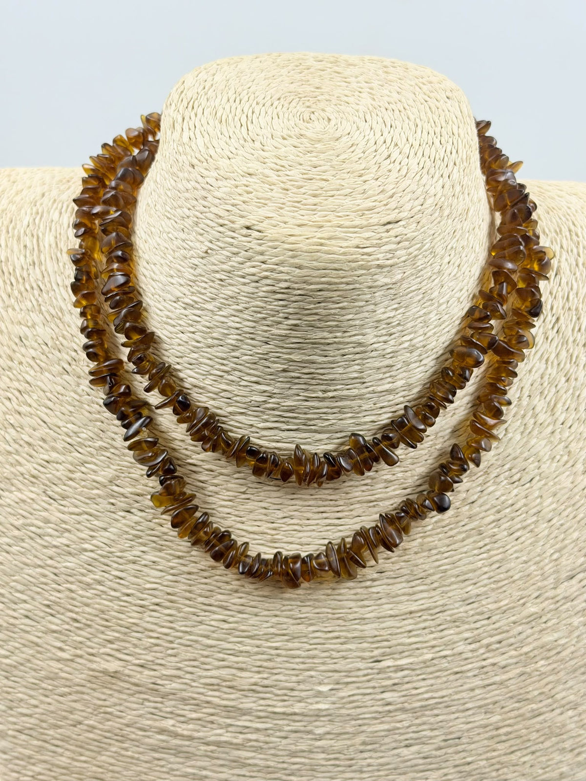 Natural brown agate chips held in hand showing translucent honey brown color