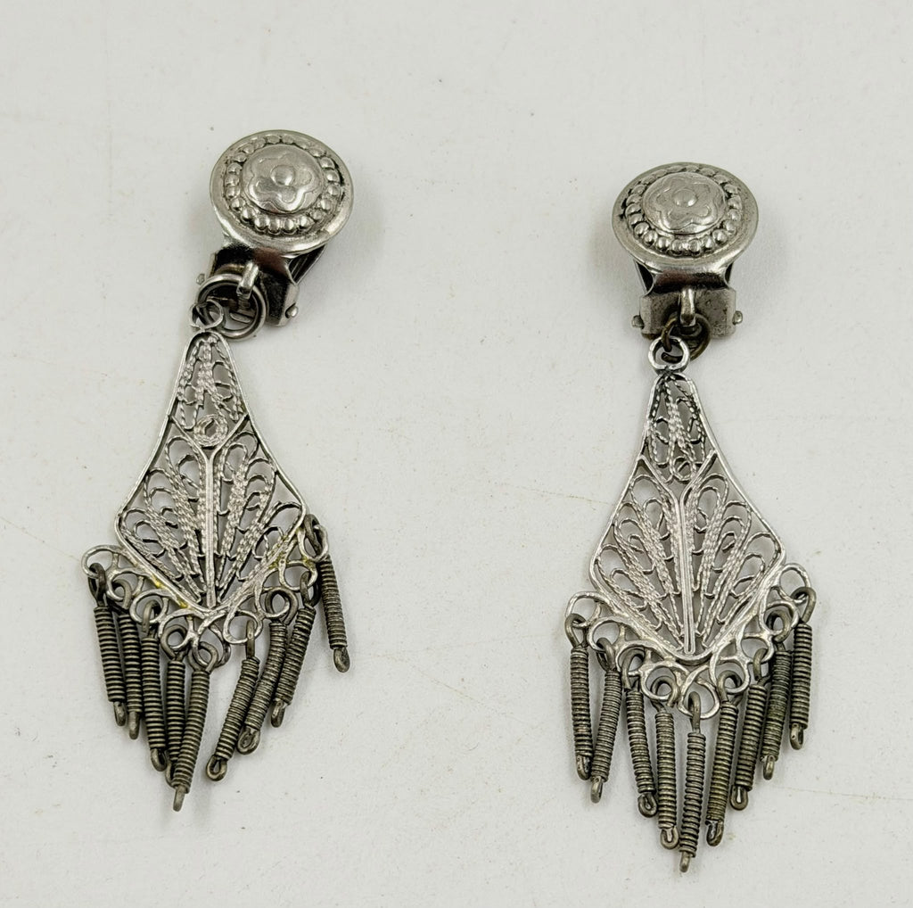 Silver filigree earrings pair on rattan background showing full length