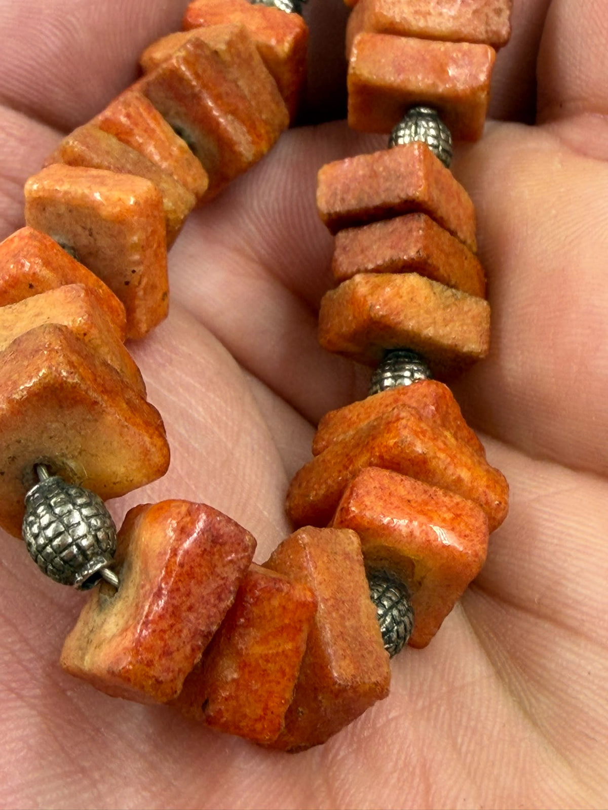 Natural coral necklace close-up of textured surface and silver spacers