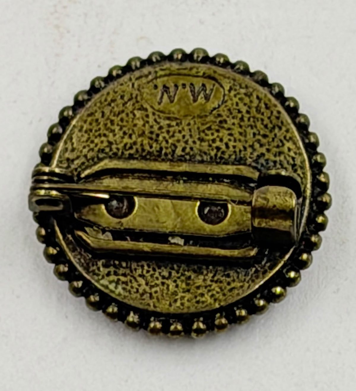 Back of brooch showing NW maker mark and pin clasp