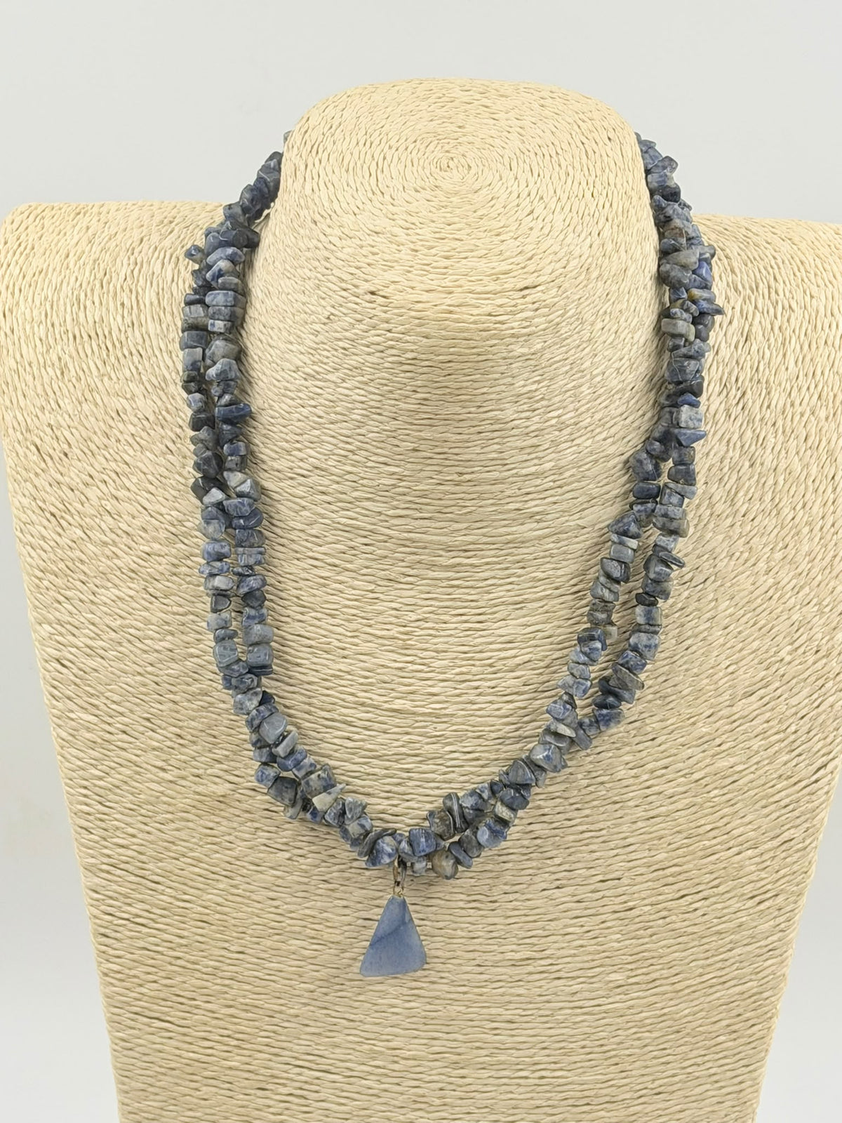 Natural sodalite chip necklace coiled on white surface showing full length and pendant