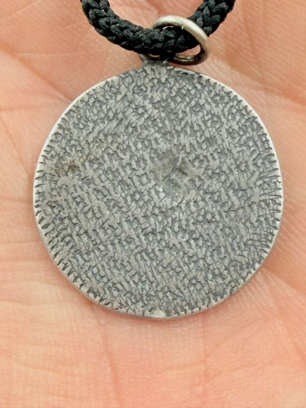 800 silver antique coin pendant in hand showing back texture close-up