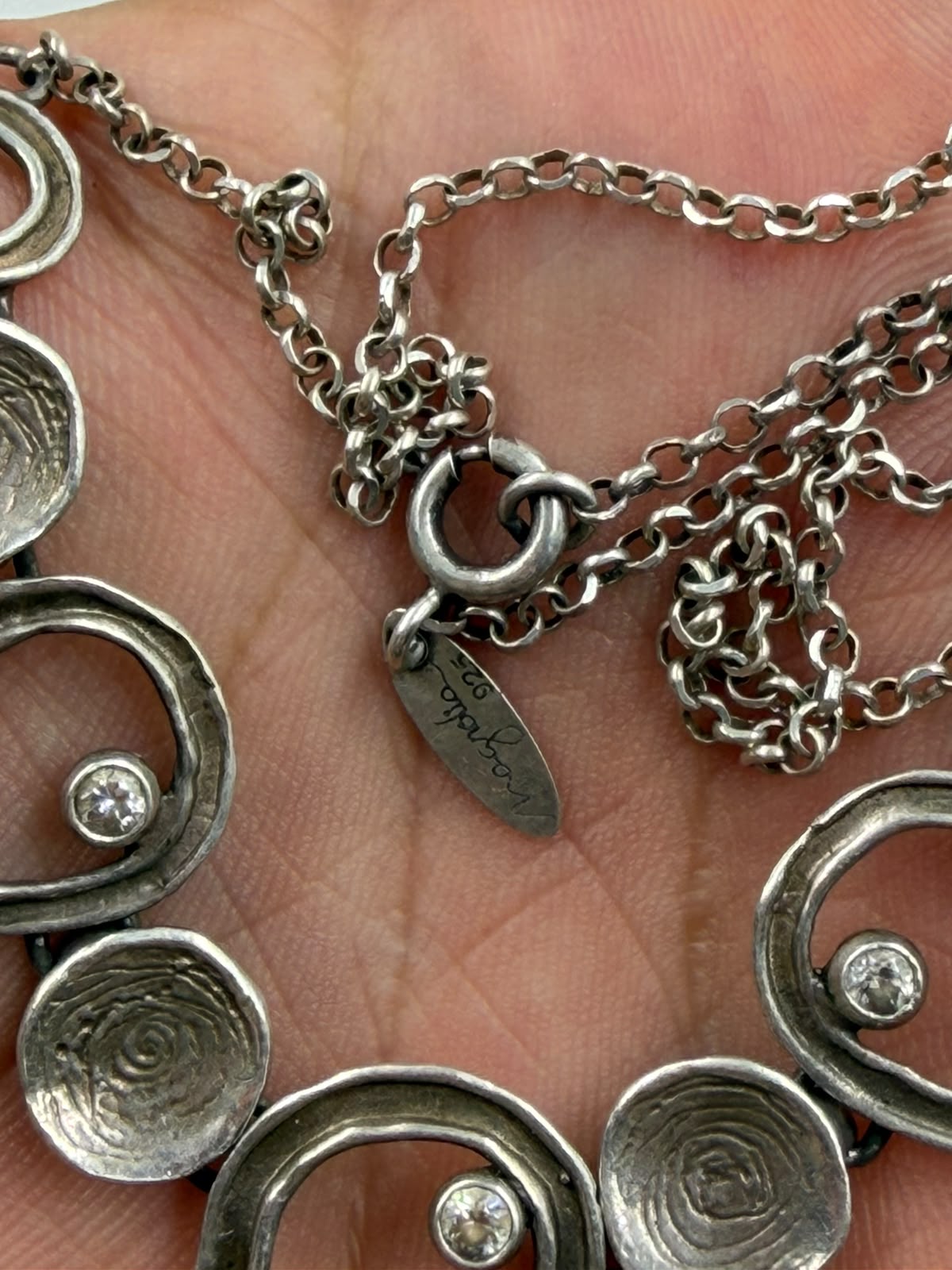 Oxidized silver spiral necklace on neutral display bust