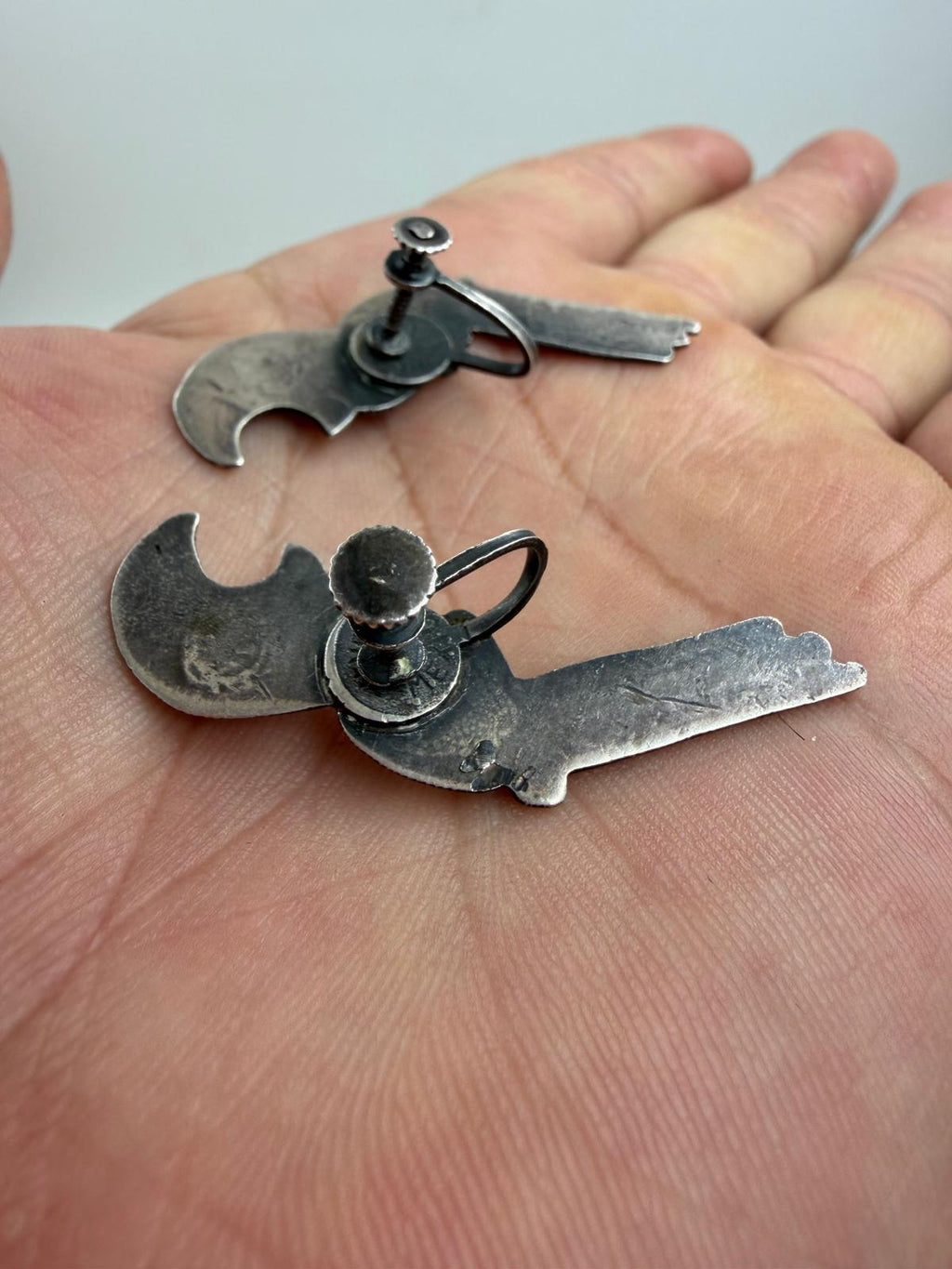 Side profile of parrot earrings in hand