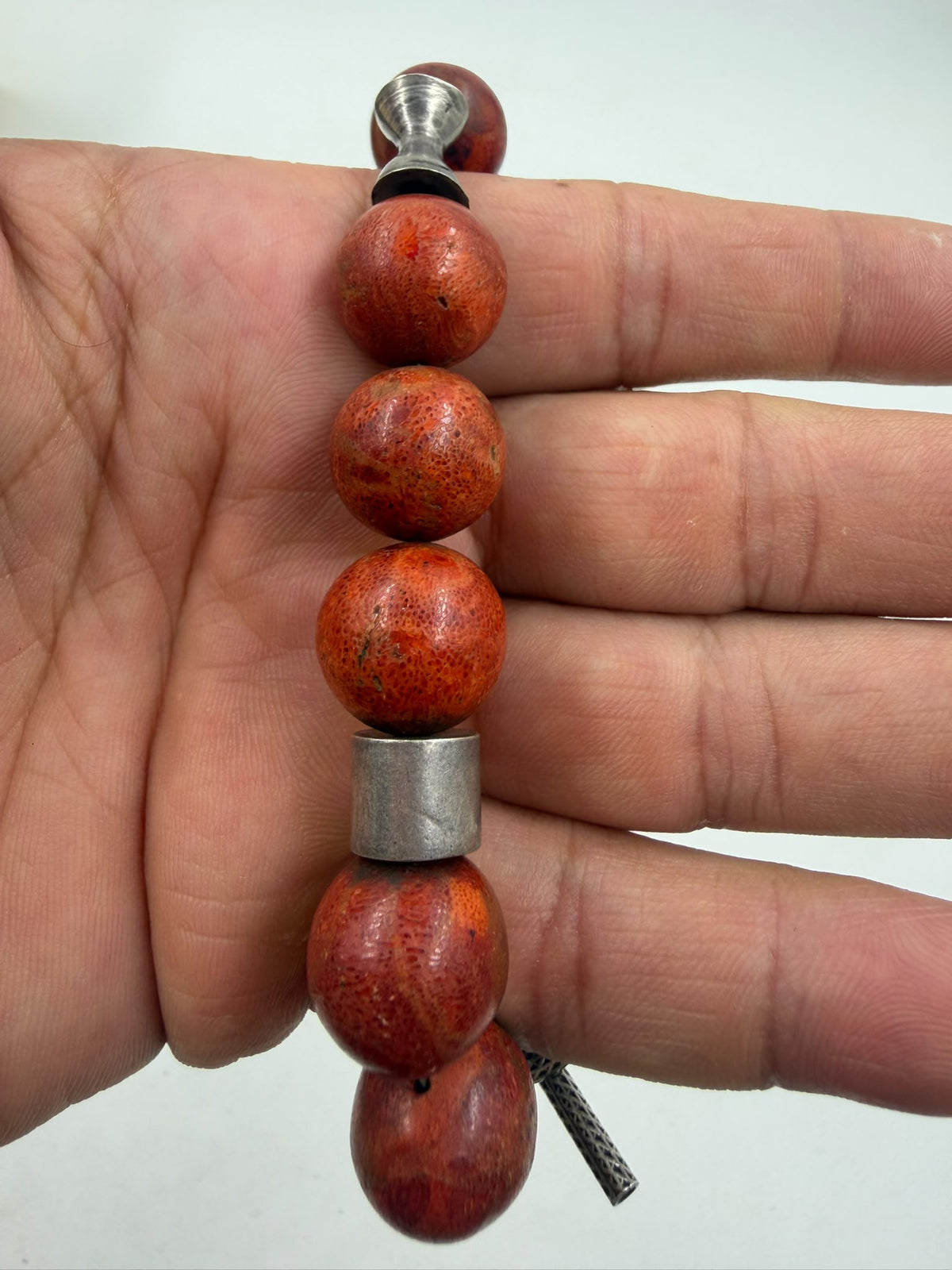 Natural red coral bracelet bead and silver barrel spacer close-up showing oxidized silver contrast