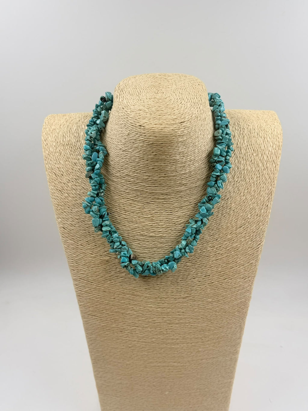 Turquoise necklace displayed on jewelry bust - side view