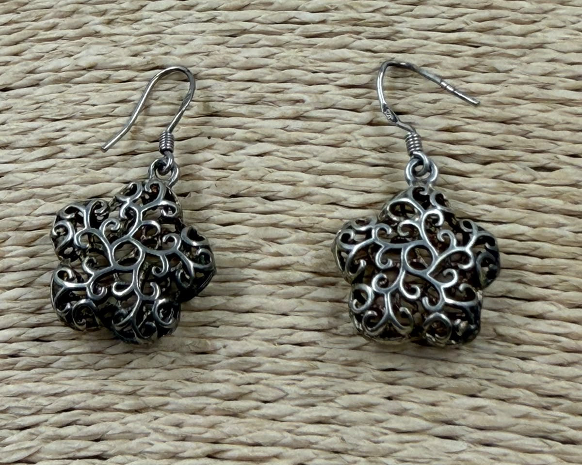 925 silver filigree flower earrings pair lifestyle photo showing oxidized silver finish in warm light