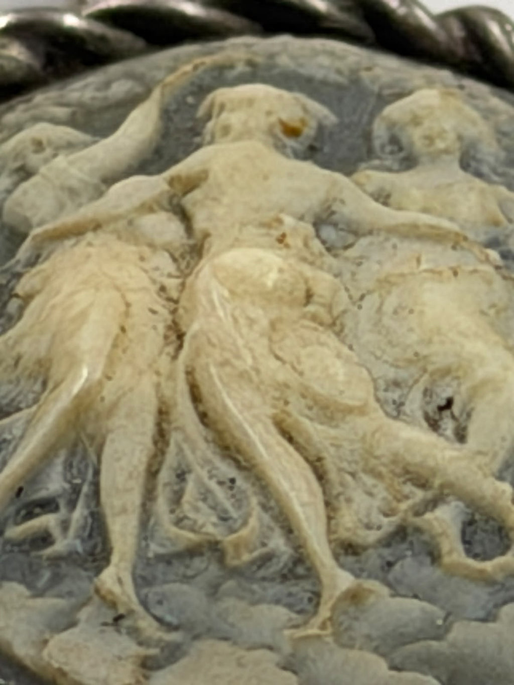 925 silver Three Graces cameo pendant held in hand side angle showing 3D relief depth and bail