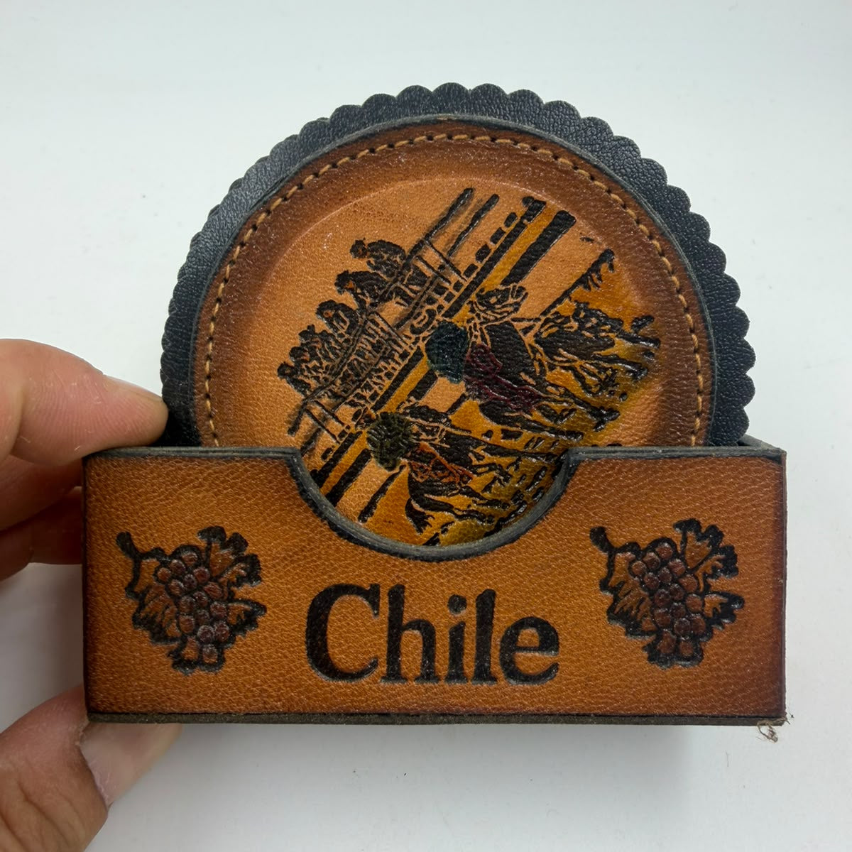 Chilean leather coaster with folk scene close-up