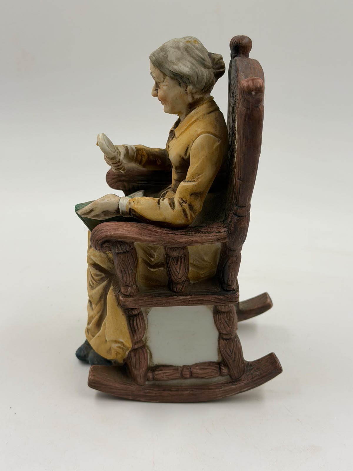 Vintage resin grandma reading figurine close-up of hands and book detail