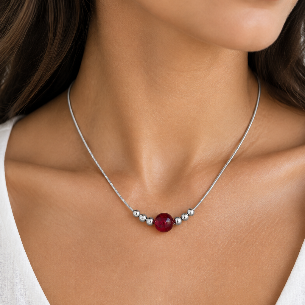 Woman wearing sterling silver snake chain necklace with red carnelian bead